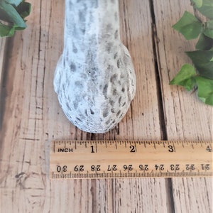 Puede incluir: Una figurita de pollo de cer&aacute;mica blanca con un acabado moteado gris. La figurita mide aproximadamente 5 cm de alto.