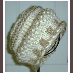 May include: A white and brown knitted hat with a cable knit pattern.
