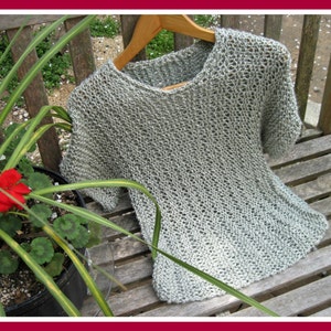 May include: A light gray knitted top with a loose fit and short sleeves. The top is made of a delicate, open-weave fabric.