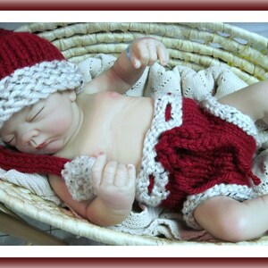May include: A red and white knitted hat and diaper set for a baby. The hat has a long, pointed tip and a white brim. The diaper has a white trim and a red center.