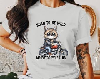 Könnte beinhalten: Weißes T-Shirt mit einer Cartoon-Katze mit Sonnenbrille und Lederjacke, die ein rotes Motorrad fährt. Der Text "BORN TO BE WILD" und "MEOWTORCYCLE CLUB" ist über und unter der Katzenillustration aufgedruckt.