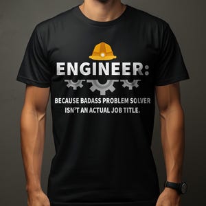 Puede incluir: Camiseta negra con la palabra "ENGINEER" en blanco, un gráfico de casco amarillo y el texto "BECAUSE BADASS PROBLEM SOLVER ISN'T AN ACTUAL JOB TITLE." La camiseta la lleva una persona.
