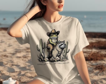 Funny Cowboy Frog Riding Raccoon T-Shirt: Humorous Animal Graphic Tee
