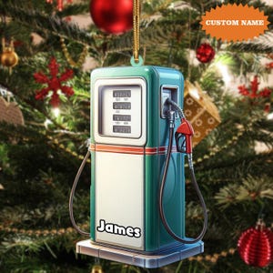 May include: A teal and white gas pump Christmas ornament with a red nozzle and the name "James" on the front. The ornament has a gold hanging string and the text "CUSTOM NAME" on a tag.