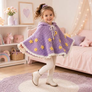 May include: A lavender hooded crochet poncho featuring yellow star appliques, a white scalloped border, and a white drawstring closure with a small yellow crescent moon charm. The garment is worn over cream-colored leggings and light-colored boots.