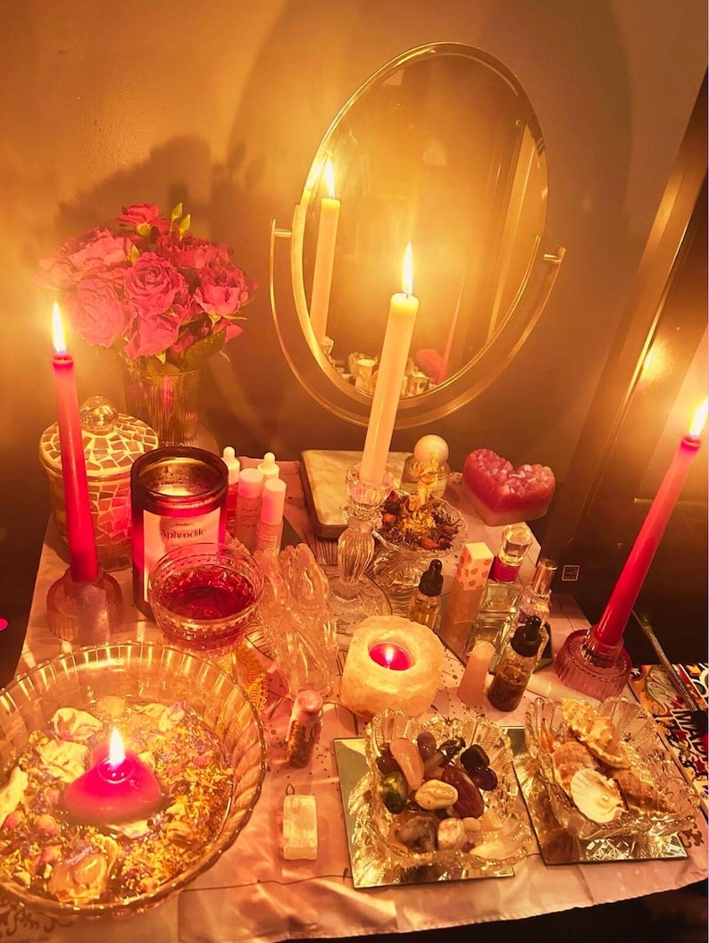 May include: A mystical altar setup with lit candles, a mirror, and various spiritual items. The scene includes red roses, glass bowls, and small bottles, creating a warm, inviting ambiance. The candles are of varying sizes and colors, adding to the spiritual theme.