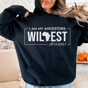 May include: Black hooded sweatshirt with a white graphic print that says "I am my ancestors wildest dreams" with an outline of the continent of Africa.