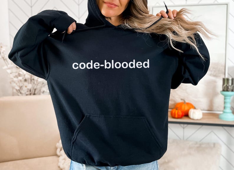 Op de afbeelding: Zwart hoodie met de tekst "code-blooded" in witte letters.