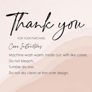 Op de afbeelding: Bedankt voor uw aankoop. Wasinstructies: Machinewas warm, binnenstebuiten, met gelijke kleuren. Niet bleken. Drogen in de droger op lage temperatuur. Niet chemisch reinigen of strijken over het ontwerp.