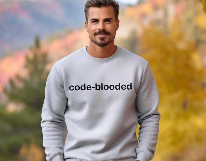 Op de afbeelding: Een grijs sweatshirt met de tekst "code-blooded" in zwart op de voorkant.