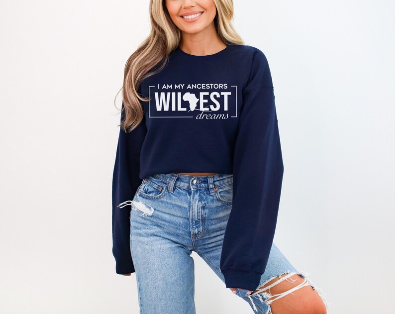 May include: A navy blue cropped sweatshirt with the text "I am my ancestors wildest dreams" and a white outline of the continent of Africa.