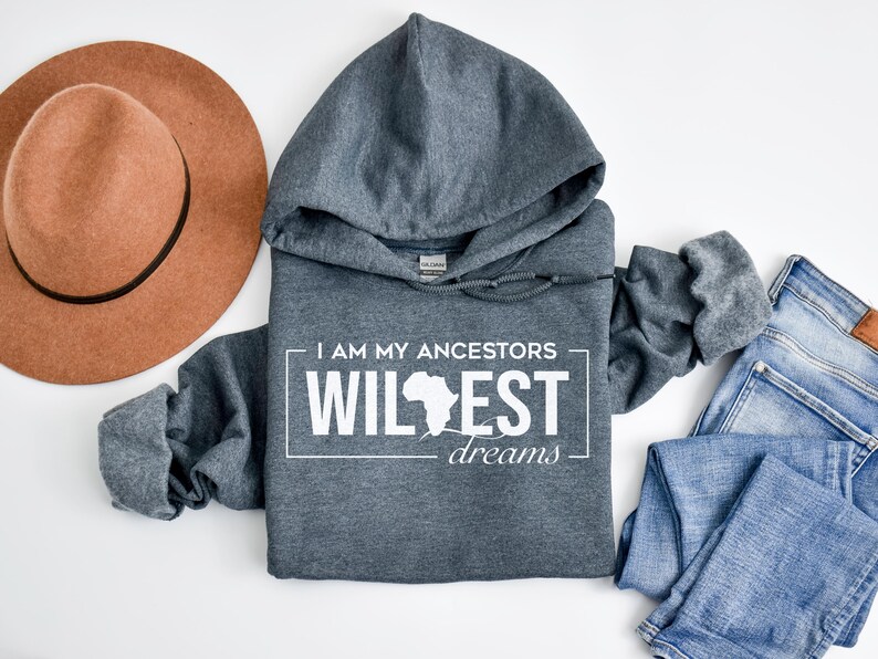May include: A dark gray hooded sweatshirt with the text "I am my ancestors wildest dreams" and an outline of the continent of Africa in white.