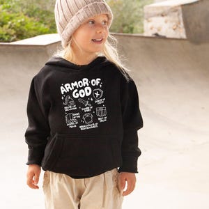 May include: A black hoodie with a white graphic print of the "Armor of God" with a list of the different pieces of armour. The hoodie has a hood and a kangaroo pocket.