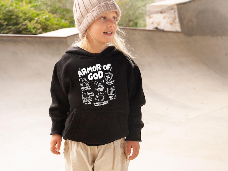 May include: A black hoodie with a white graphic print of the "Armor of God" with a list of the different pieces of armour. The hoodie has a hood and a kangaroo pocket.