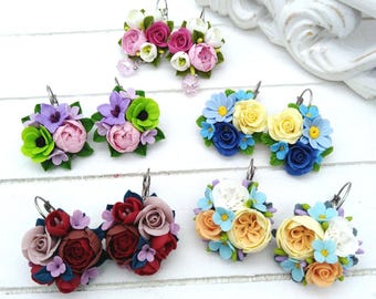 May include: Five pairs of handmade polymer clay earrings featuring different flower arrangements. The earrings are in shades of pink, purple, green, blue, and yellow.