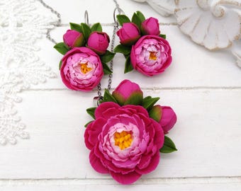 Peut inclure: Un collier et des boucles d'oreilles en forme de pivoine rose. Le collier et les boucles d'oreilles présentent un groupe de fleurs de pivoine roses avec des feuilles vertes.