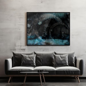 Peut inclure: Une impression d'art abstrait dans un cadre noir est suspendue au-dessus d'un canapé gris avec trois coussins. L'œuvre présente des coups de pinceau bleu foncé et noir. Une petite table d'appoint noire contient une plante en pot.