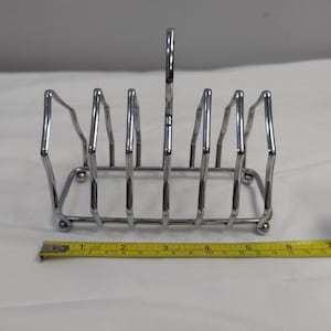 Tostadora Art Déco: Seis rebanadas de metal plateado, patas esféricas, fabricada en Inglaterra