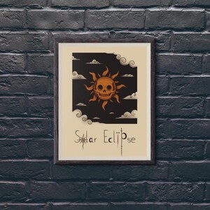 Könnte beinhalten: Gerahmter Kunstdruck mit einer stilisierten Darstellung einer Totenkopfsonne vor einem schwarzen Himmel mit Wolken. Die Worte "Solar Eclipse" sind in einer dekorativen Schriftart darunter geschrieben. Das Kunstwerk ist in einem dunkelbraunen Rahmen gerahmt.