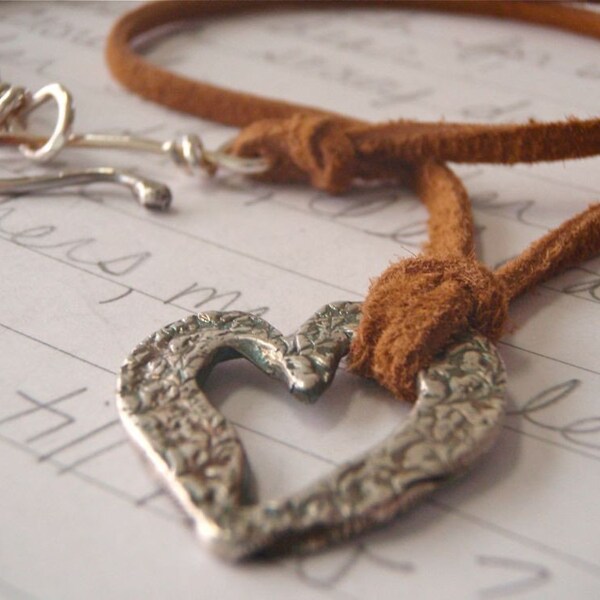love token necklace. silver metalwork heart pendant on suede
