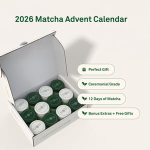 May include: A white cardboard box labelled 2026 Matcha Advent Calendar containing twelve small jars with alternating white and dark green lids. Text labels on the right list Perfect Gift, Ceremonial Grade, 12 Days of Matcha, and Bonus Extras + Free Gifts.