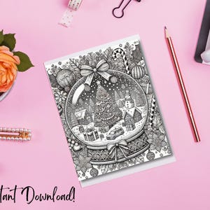 May include: A black and white Christmas-themed coloring card featuring a snow globe design with a Christmas tree, snowman, and gifts. The card is on a pink surface with the text "Instant Download!" and is surrounded by a pencil, flowers, and accessories.