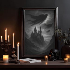 May include: A framed monochrome artwork shows a gothic castle scene with dark clouds and figures. Lit candles in ornate holders and a black skull sit on a wooden surface, creating a spooky display. A dark vase holds leafy branches.