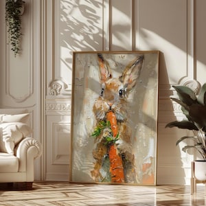 May include: A framed oil painting of a brown rabbit eating a large orange carrot. The rabbit has long ears and is set against a neutral background. The artwork is displayed in a room with a white sofa and a potted plant.