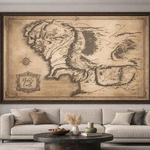 May include: A large framed map of Middle Earth, featuring detailed geographical illustrations in shades of brown and beige. The map is displayed above a beige sofa, creating a focal point in the room. The map includes a compass rose and the words "Middle Earth".