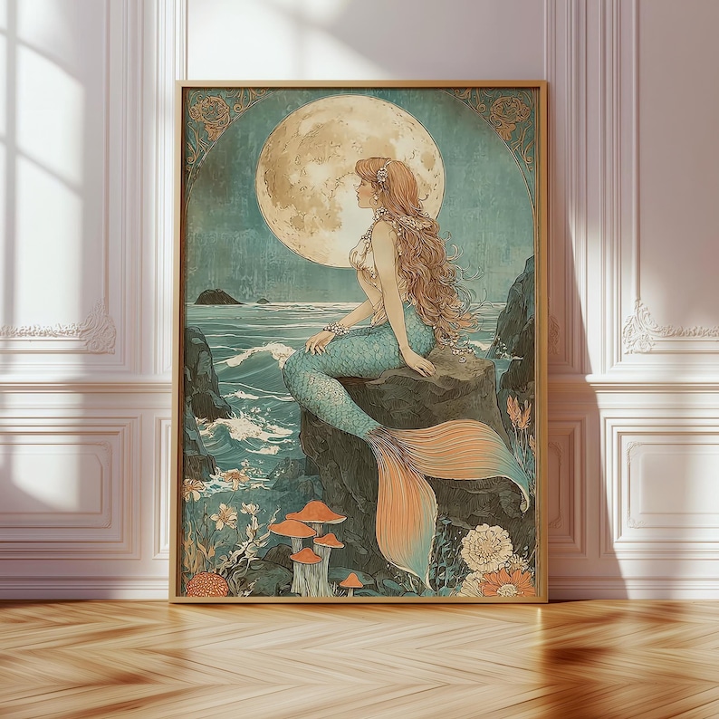 May include: A framed art print featuring a mermaid sitting on a rock, gazing at a full moon. The mermaid has long auburn hair and a turquoise tail. The artwork has a vintage style with muted colors and floral accents.