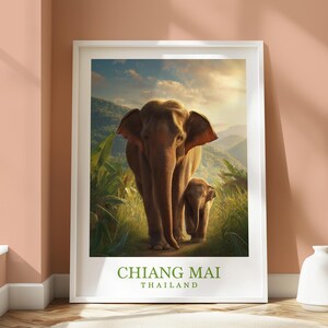 Puede incluir: Un póster enmarcado que muestra dos elefantes caminando por un exuberante paisaje verde. El elefante más grande lidera a uno más pequeño, con montañas y una puesta de sol al fondo. El texto "CHIANG MAI THAILAND" está en la parte inferior.