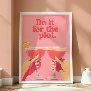 Peut inclure: Affiche rose et rouge avec le texte "Do it for the plot." Deux cocktails roses avec des quartiers de citron vert sont en train de trinquer.