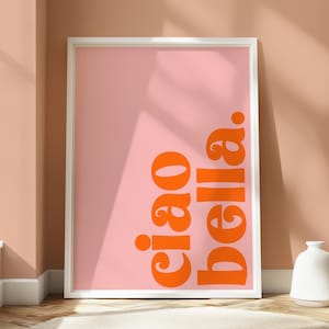 May include: A white framed poster with a pink background and the text "ciao bella" in orange.