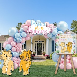 May include: A balloon arch in pastel pink and light blue featuring a sign that reads Prince or a Princess. Two lion cub cutouts with gold crowns stand in front. A square sign on an easel displays the text What is it going to be Princess or Prince.