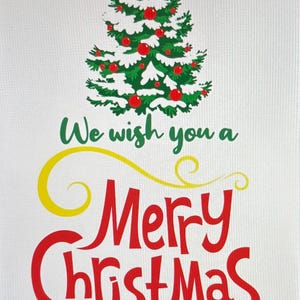 K&ouml;nnte beinhalten: Weihnachtsgrafik mit einem gr&uuml;nen Weihnachtsbaum, der mit roten Kugeln und wei&szlig;em Schnee geschm&uuml;ckt ist. Der Text "We wish you a Merry Christmas" ist in Gr&uuml;n, Gelb und Rot geschrieben.
