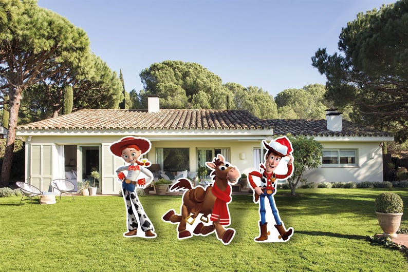 May include: Cardboard cutouts of Jessie, Bullseye, and Woody from Toy Story stand on a green lawn in front of a house. Jessie wears a red hat, white shirt, and cow-print trousers. Woody wears a cowboy hat and vest. Bullseye has a red scarf.