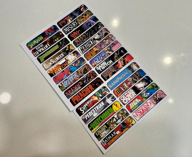 Peut inclure: Un ensemble de 20 autocollants color&eacute;s sur le th&egrave;me des bandes dessin&eacute;es avec des titres tels que Spawn, Misery, Gunslinger, Preacher, Sandman et Watchmen.
