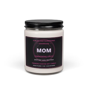 May include: A white soy candle in a clear glass jar with a black lid. The black label features pink text reading GOBLINS AND GLOWWORMS, PERSONALIZED, MOM, SUMMONING CIRCLE, speak their name three times, PREMIUM SCENTED SOY CANDLE, HAND-POURED, 9 OZ, 50-60 HR BURN.