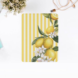 May include: A rectangular, yellow and white striped notebook with a watercolor illustration of lemons, leaves, and white flowers. The design is on the right side of the notebook.