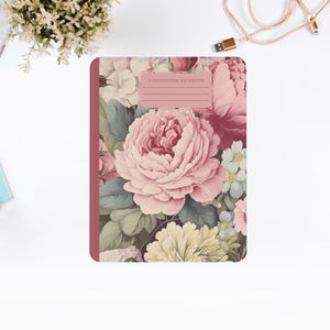 Puede incluir: Una libreta de composición rosa con un diseño floral con rosas rosas, blancas y verdes. La portada tiene el texto "COMPOSITION NOTEBOOK" impreso.