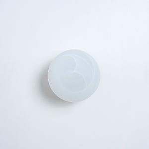 May include: White round silicone mold with a swirl design.