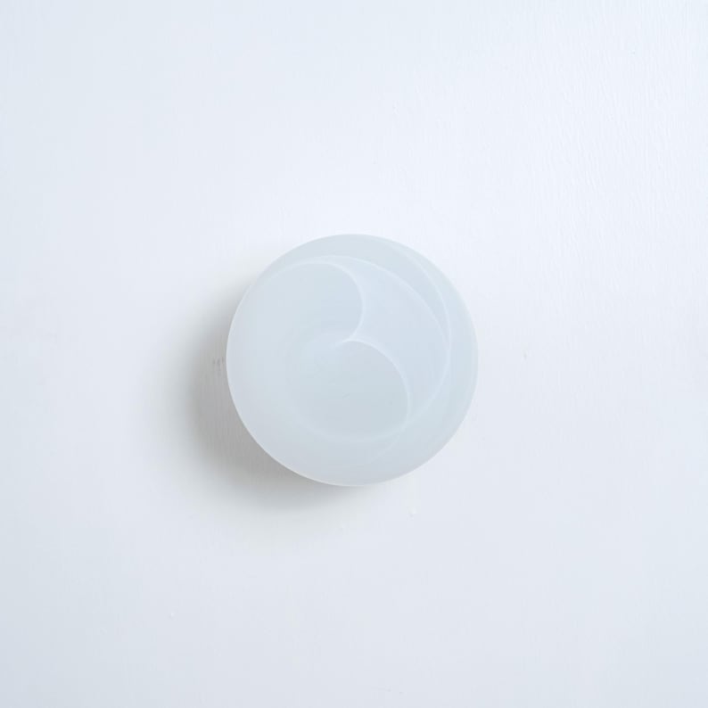 May include: White round silicone mold with a swirl design.