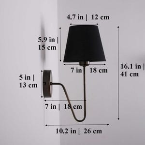 May include: A black wall sconce with a dark bronze finish. The lamp has a black lampshade, measuring 4.7 inches (12 cm) in diameter and 5.9 inches (15 cm) in height. The sconce extends 10.2 inches (26 cm) from the wall and is 16.1 inches (41 cm) tall.