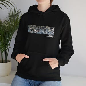 May include: Black hoodie featuring a graphic print of a colourful illustration. The text "Lola Valdès, Comunidad y Colectivo, 2021" is printed below the graphic.
