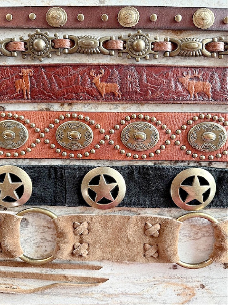 Peut inclure: Cinq ceintures en cuir diff&eacute;rentes avec divers accents m&eacute;talliques. Les ceintures pr&eacute;sentent diff&eacute;rents motifs, notamment des &eacute;toiles, des cercles et des silhouettes d'animaux. Les ceintures sont toutes de couleur marron ou noire.