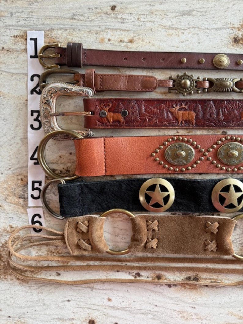 Peut inclure: Six ceintures en cuir diff&eacute;rentes avec diff&eacute;rentes boucles et embellissements. Les ceintures sont num&eacute;rot&eacute;es de 1 &agrave; 6. Les ceintures sont brunes, noires et beiges.