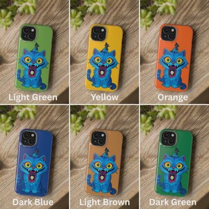 May include: A collection of colorful phone cases, each featuring a cartoon cat design. The cases are in various colors, including light green, yellow, orange, dark blue, light brown, and dark green. Each case has the text of its color printed on it.