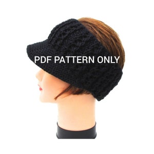 Puede incluir: Diadema negra de punto con visera. La diadema está hecha de un hilo grueso y tiene un diseño simple y clásico. La visera es una simple pieza de tela plana que se extiende desde la parte delantera de la diadema. El texto "PDF PATTERN ONLY" está impreso en la diadema.