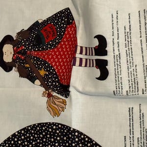 Può includere: Pannello di tessuto con un design di strega stravagante. La strega indossa un cappello nero, un mantello a stelle e una gonna rossa a pois. Porta una scopa e una borsa con la scritta "Trick or Treat".