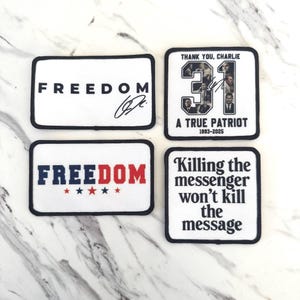 May include: Four white rectangular patches with black borders. Two patches read "FREEDOM" in black and red, with a signature and stars. One patch says "THANK YOU, CHARLIE" with "31" and "A TRUE PATRIOT 1993-2025". The last patch reads "Killing the messenger won't kill the message".